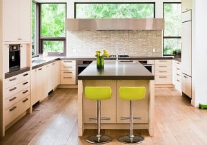 green-chairs-with-black-table-and-a-pot-of-yellow-flowers-also-there-an-oven-in-the-white-shelf-beside-a-washbasin-with-windows-behind-for-modern-kitchen-design